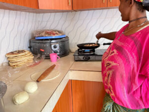 Mary Lu is in the kitchen learning to cook chapati.
